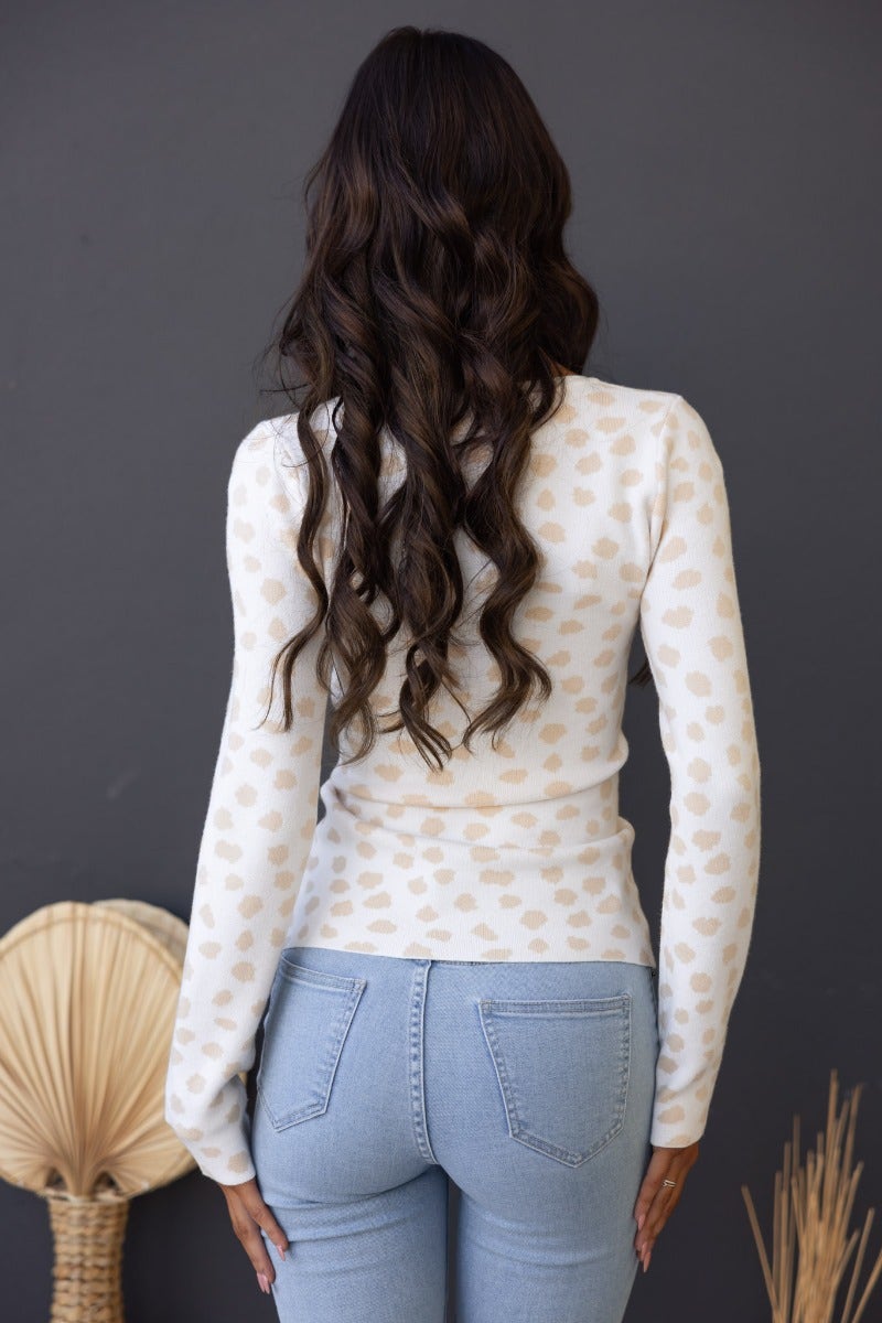 Back view of a model wearing a Greyson Top in ribbed knit with a round neckline and stylish print.