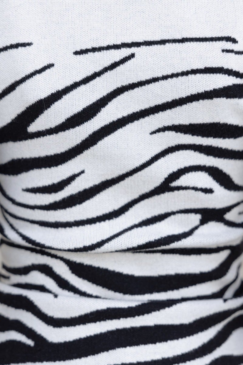Close-up of ribbed knit fabric featuring a stylish black and white zebra print design.