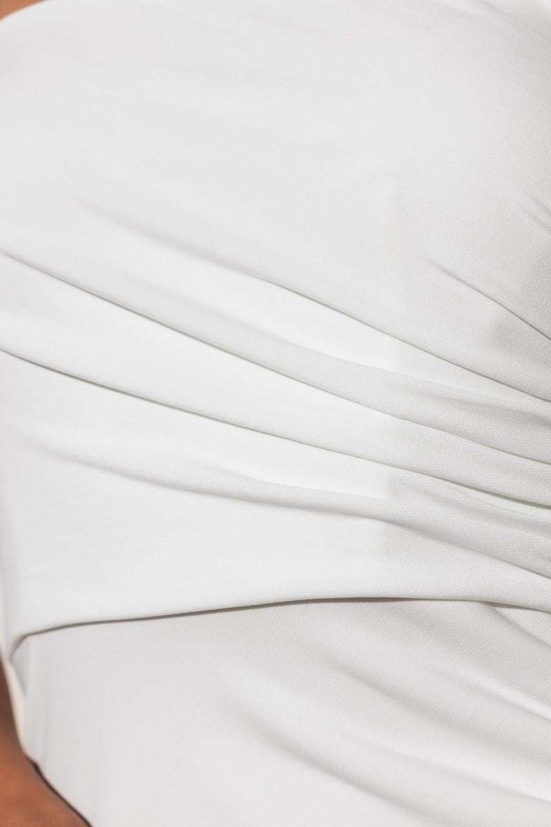Close-up of the ruching detail on a strapless Veraki maxi dress in soft white fabric, featuring a smooth texture.