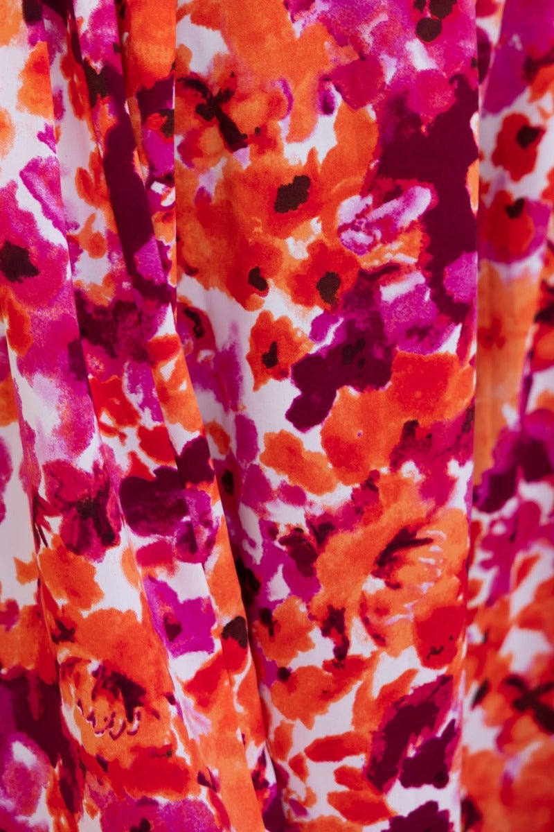 Close-up of vibrant floral print in shades of orange and purple on the Andreas Midi Dress fabric.