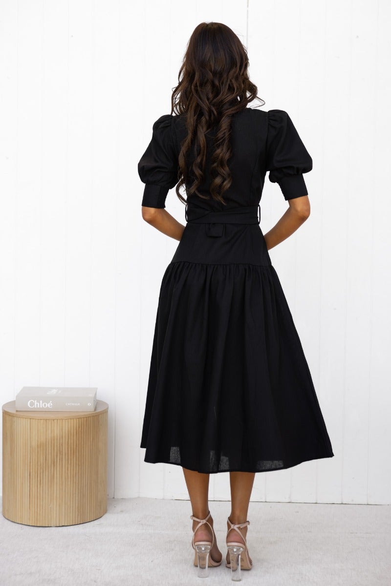Back view of a black linen blend midi dress with puff sleeves and a removable belt.