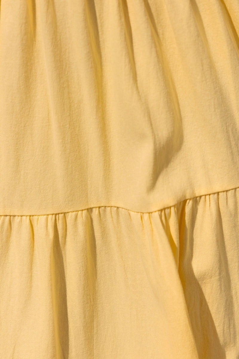 Close-up of yellow cotton fabric highlighting pleats and tiers of a Posh Maxi Dress.
