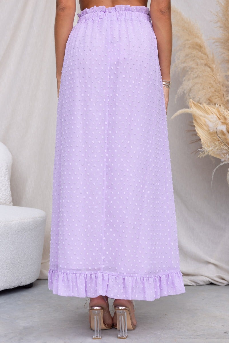 Back view of Rosalia Maxi Skirt in lavender with textured fabric and ruffled hem, showcasing elastic waistband.