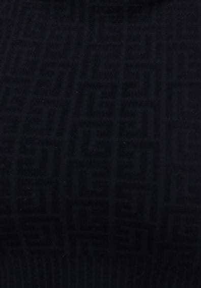 Close-up of the embossed black fabric of the Uxbridge Dress, showcasing its stretch material and intricate pattern.