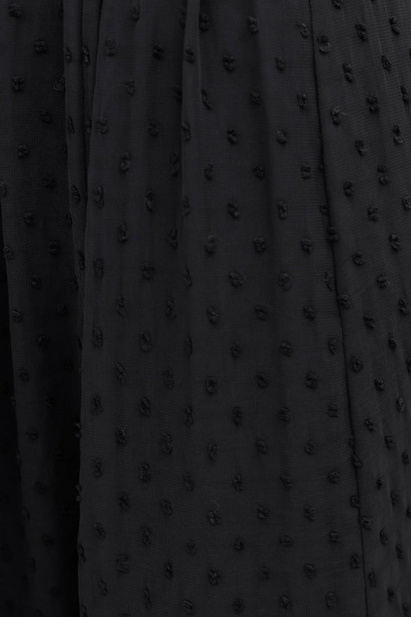 Close-up of black textured fabric with raised dots, perfect for stylish tops like the Rosalia Top.