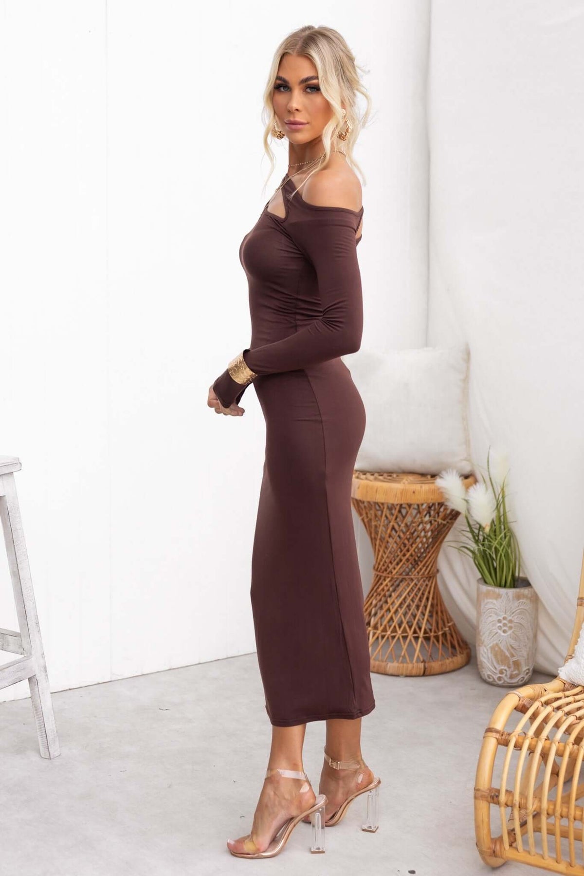 Model wearing Alatri Maxi Dress in brown, showcasing a fitted cut, off-shoulder design, perfect for casual or formal events.
