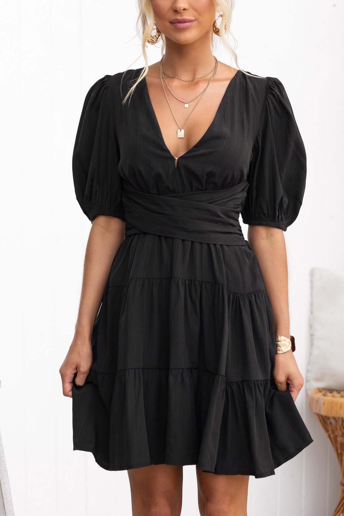 Sakura Dress featuring a black V-neckline design with puff sleeves and layered skirt style, perfect for a chic look.
