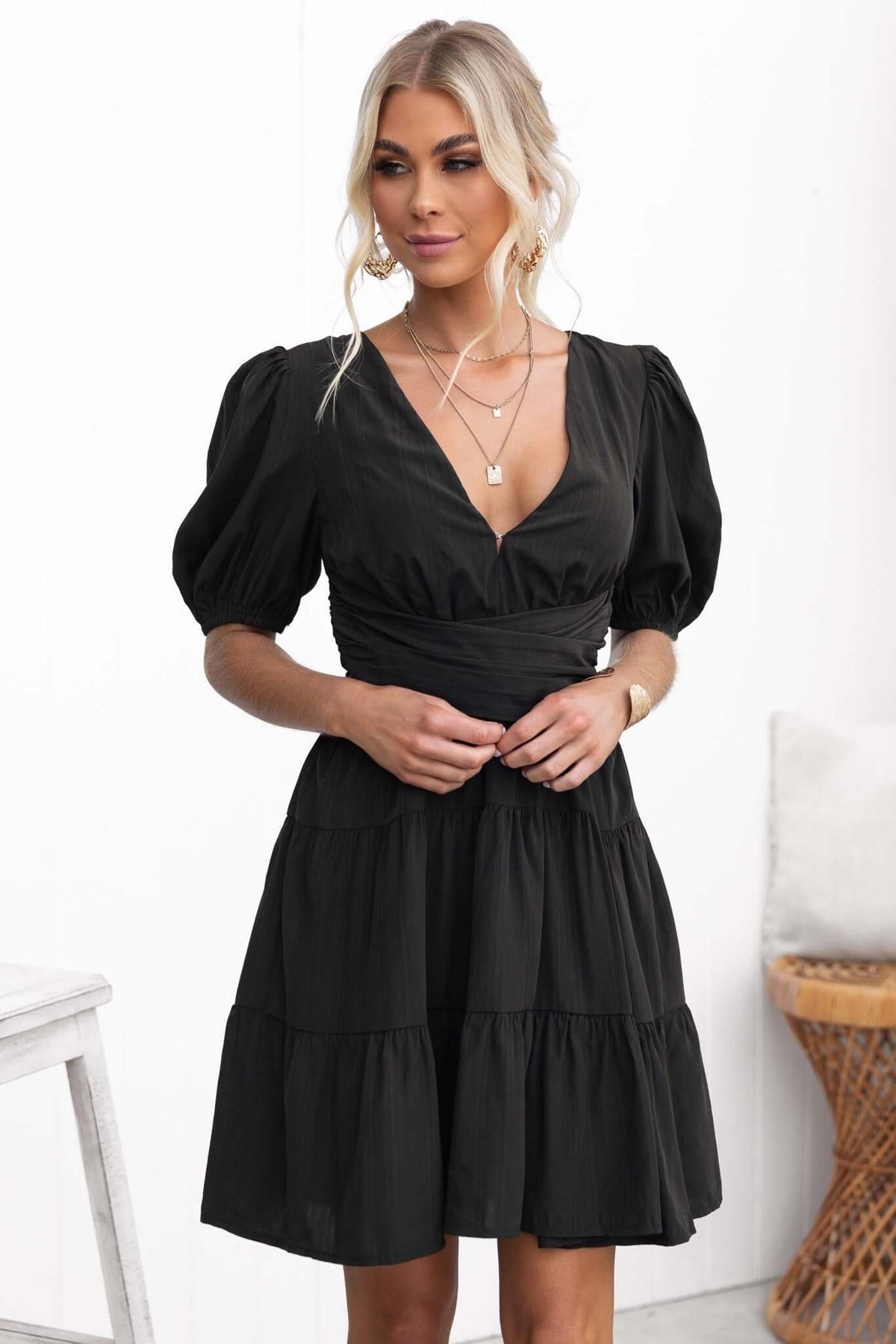Sakura Dress in black with V-neckline, puff sleeves, and tiered skirt, perfect for casual outings.