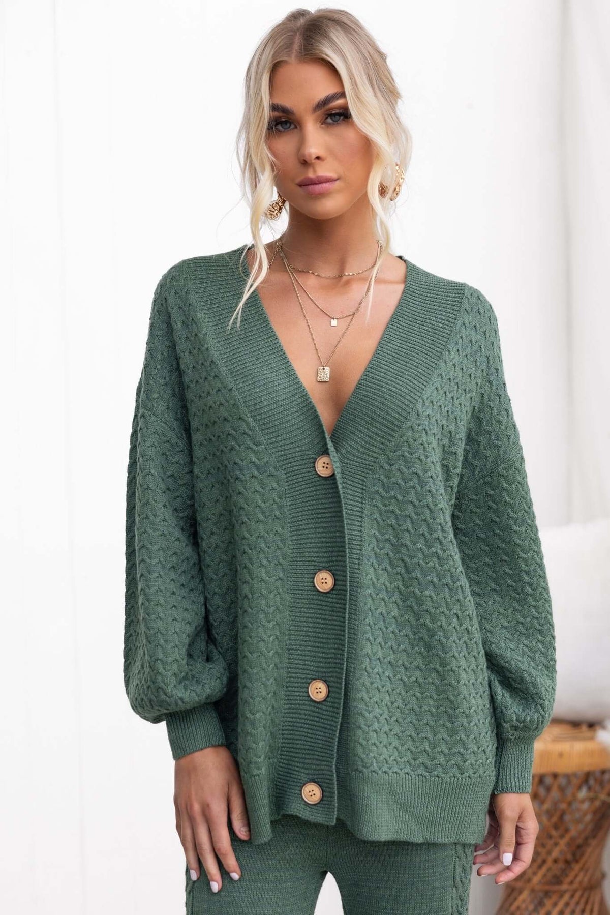Jesse Cardigan in green, featuring a V-neckline, button-up front, and knitted texture for a relaxed fit.