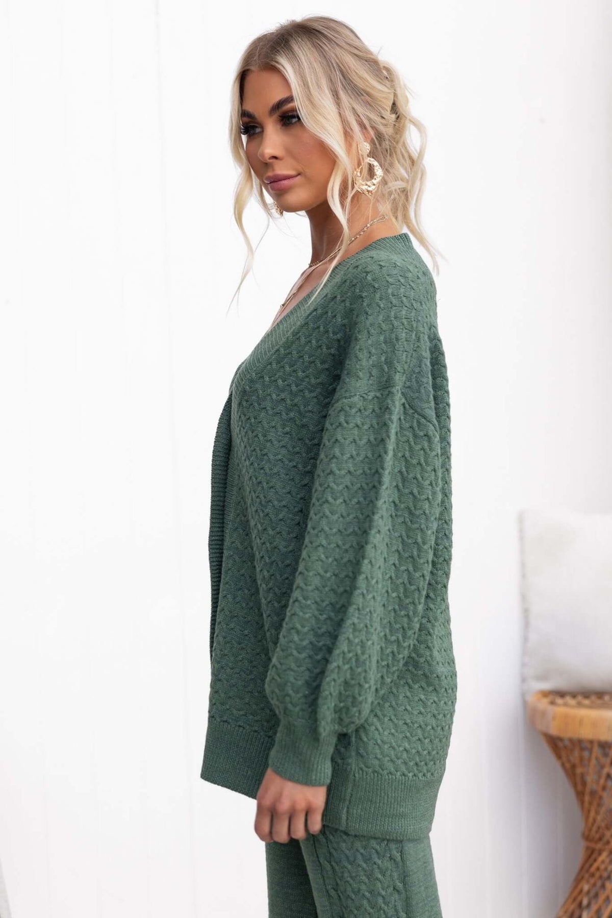 Model wearing the Jesse Cardigan in green, featuring a V-neckline and relaxed fit, styled with matching pants.
