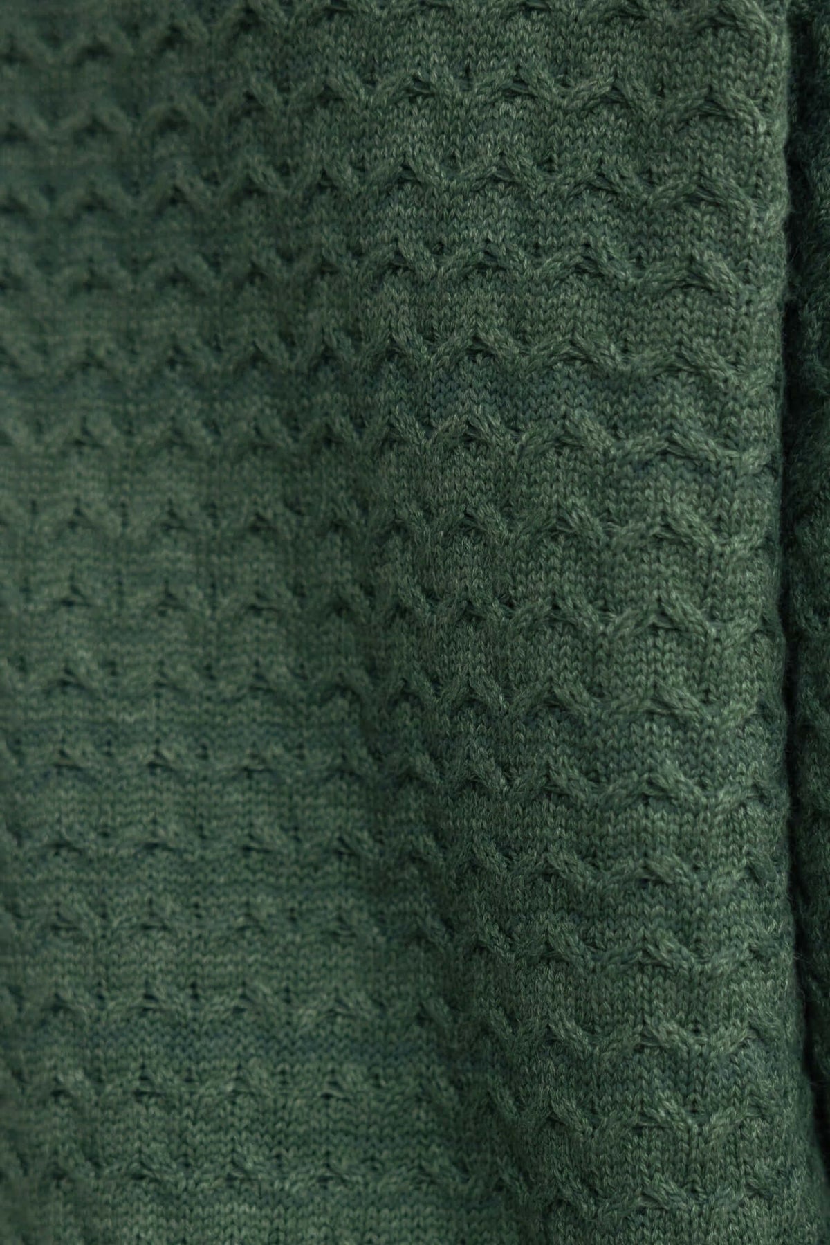 Close-up of textured green knit fabric, showcasing the intricate pattern and soft material of Jesse Pants.
