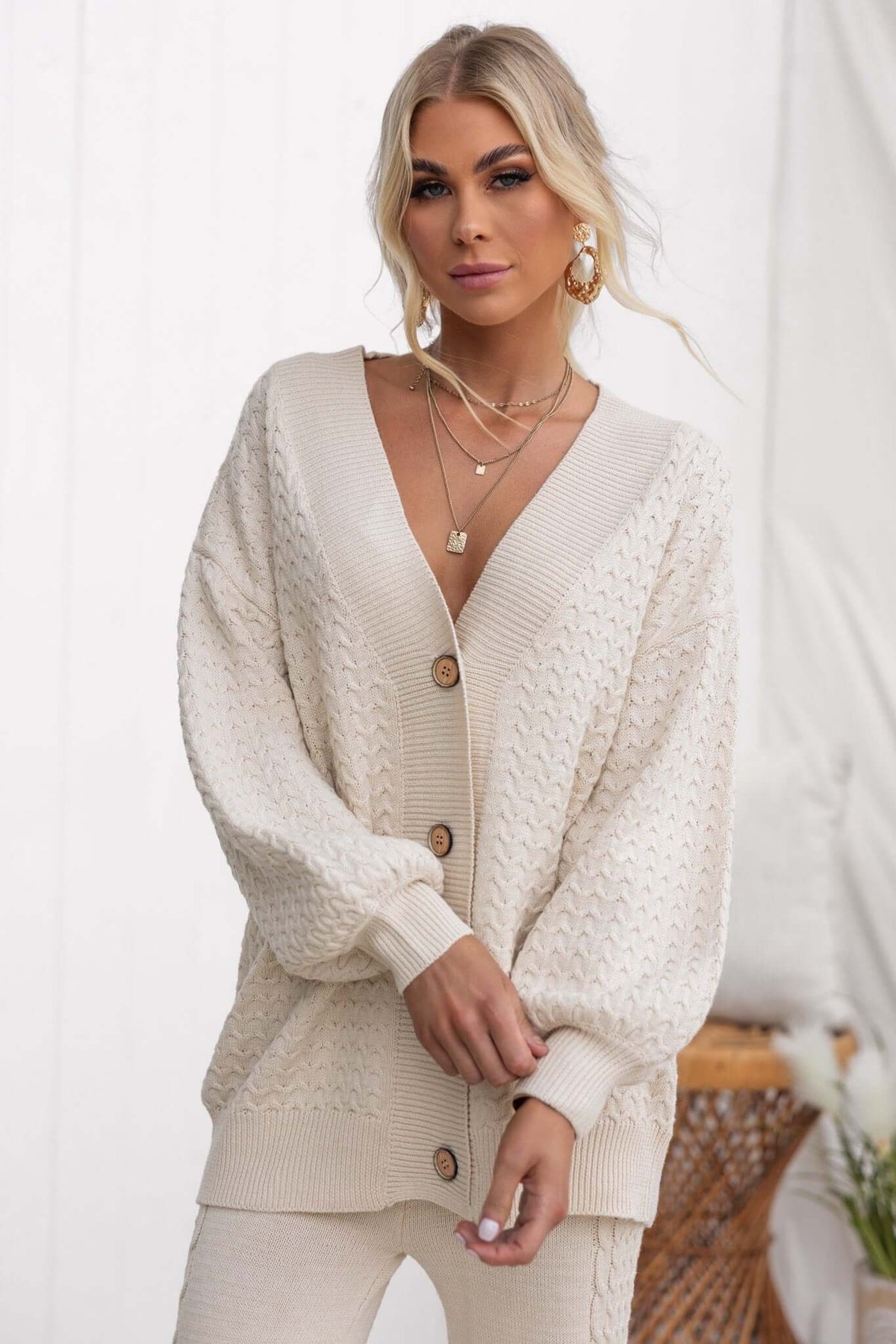 Stylish cream Jesse cardigan with V-neckline and button-up front, made of stretchy knit material, perfect for a relaxed fit.