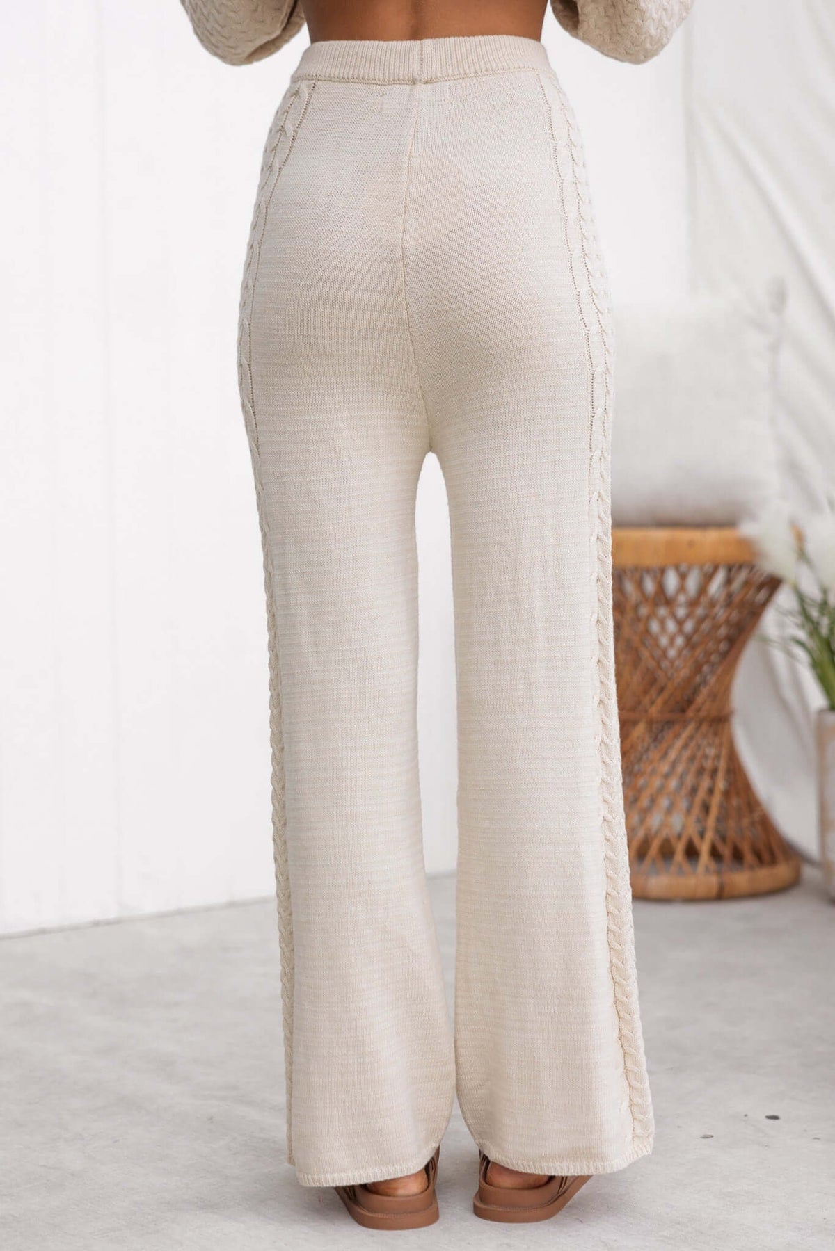 Back view of Jesse Pants, featuring a beige drop-crotch style with knit material and elastic waistband.