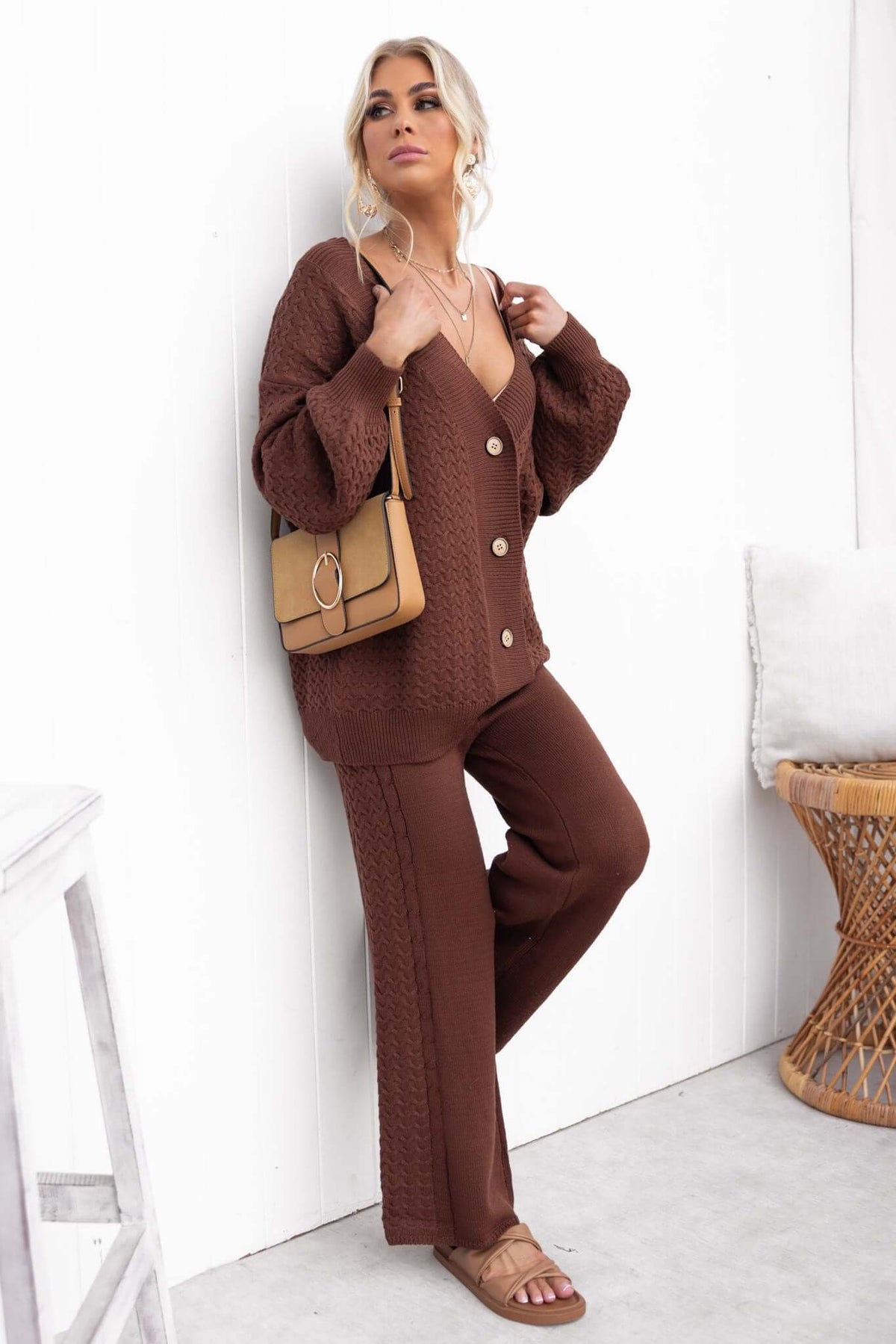 Stylish woman in a brown Jesse Cardigan with V-neckline, button-up front, paired with matching pants.