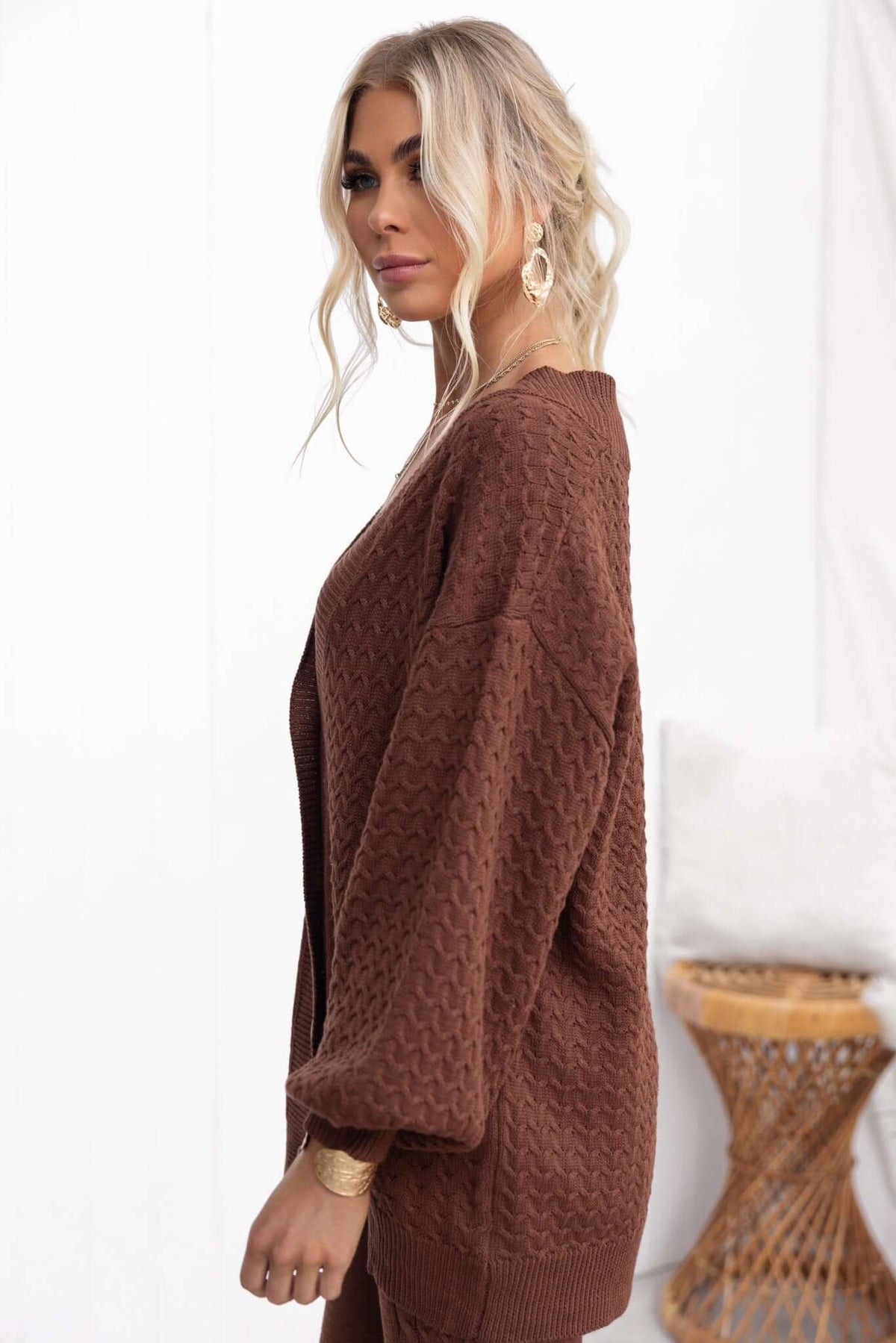 Side view of a woman wearing a brown Jesse Cardigan with a relaxed fit and knit texture, showcasing a casual style.
