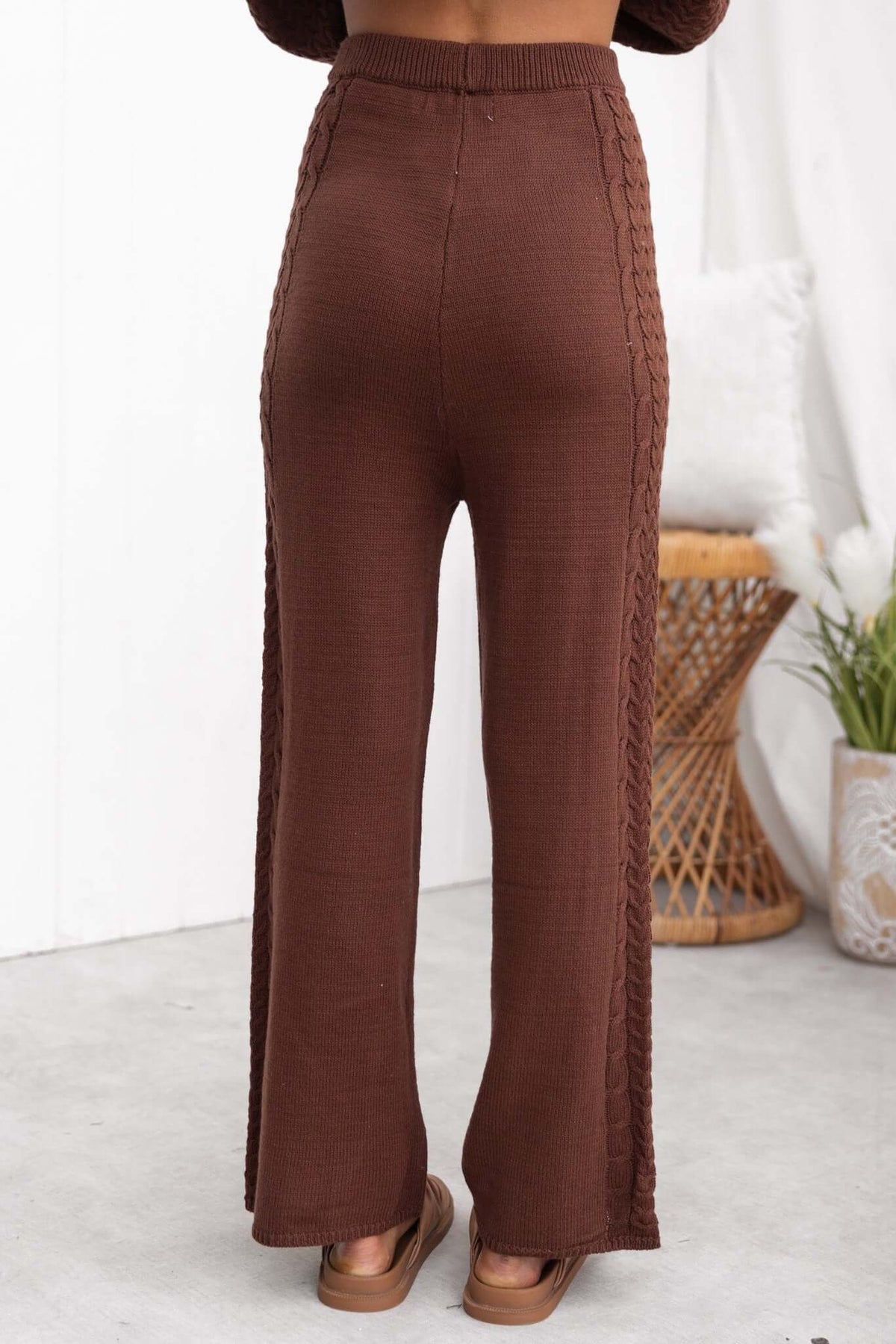 Back view of Jesse Pants in brown, featuring a drop crotch style and knit material with intricate side detailing.