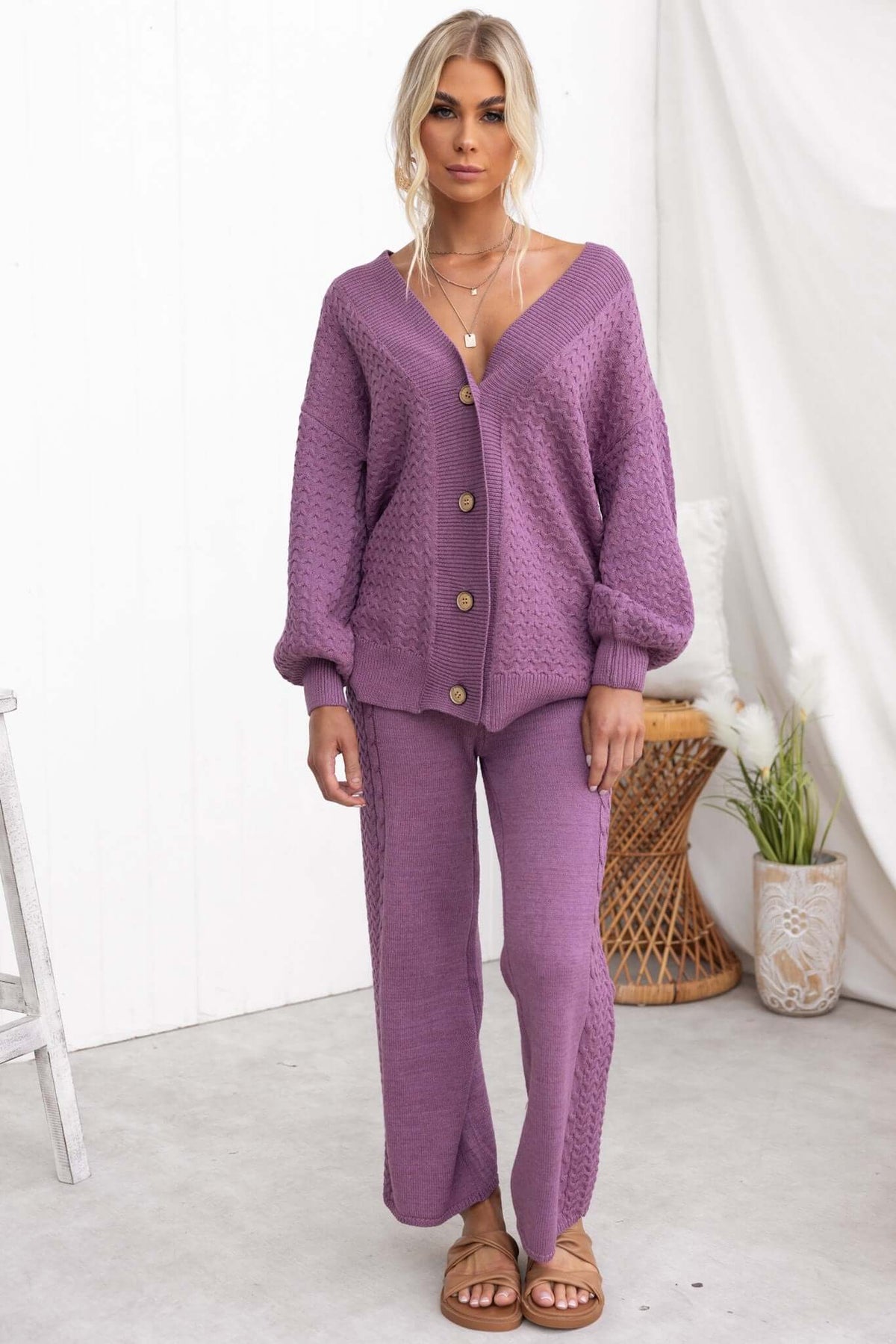 Model wearing a purple Jesse Cardigan with V-neckline and button-up front, styled with matching pants.