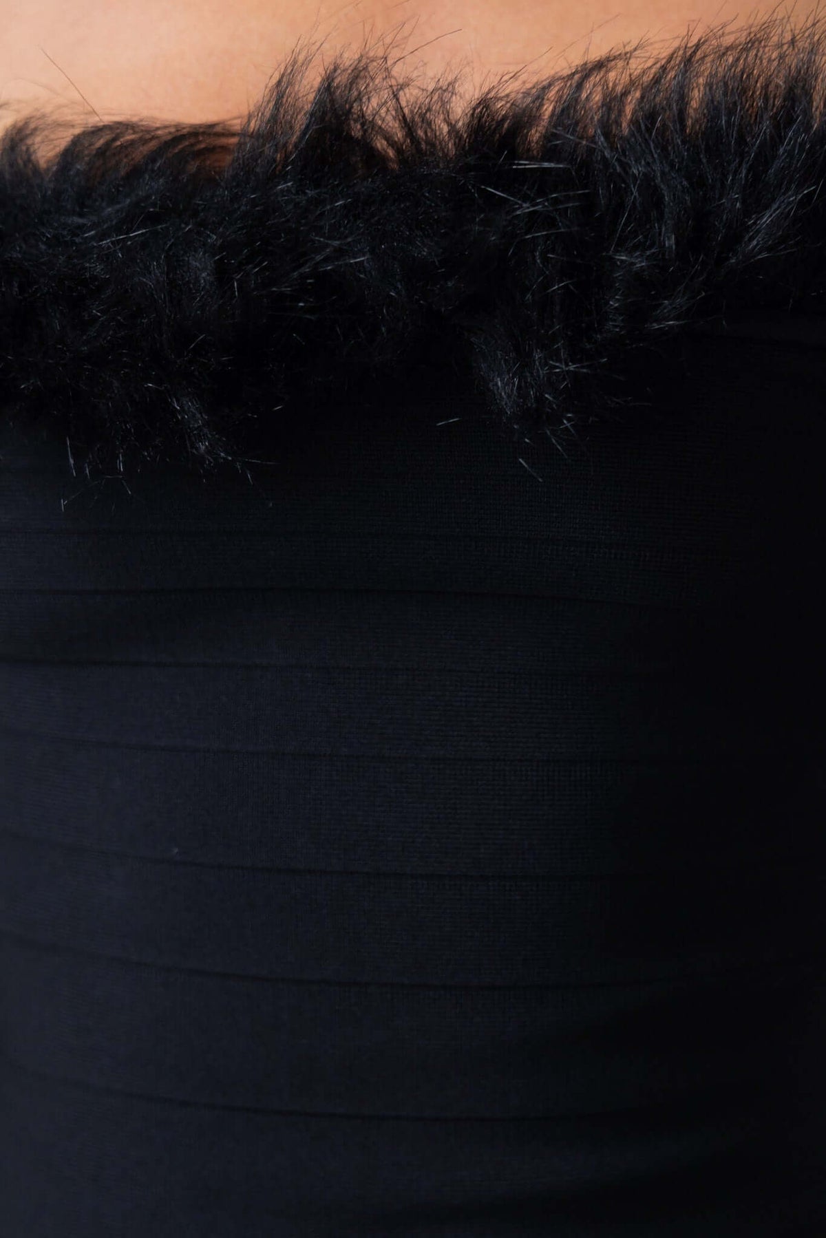 Close-up of the Shimmie Dress showcasing its black strapless design with fluffy trim at the neckline.