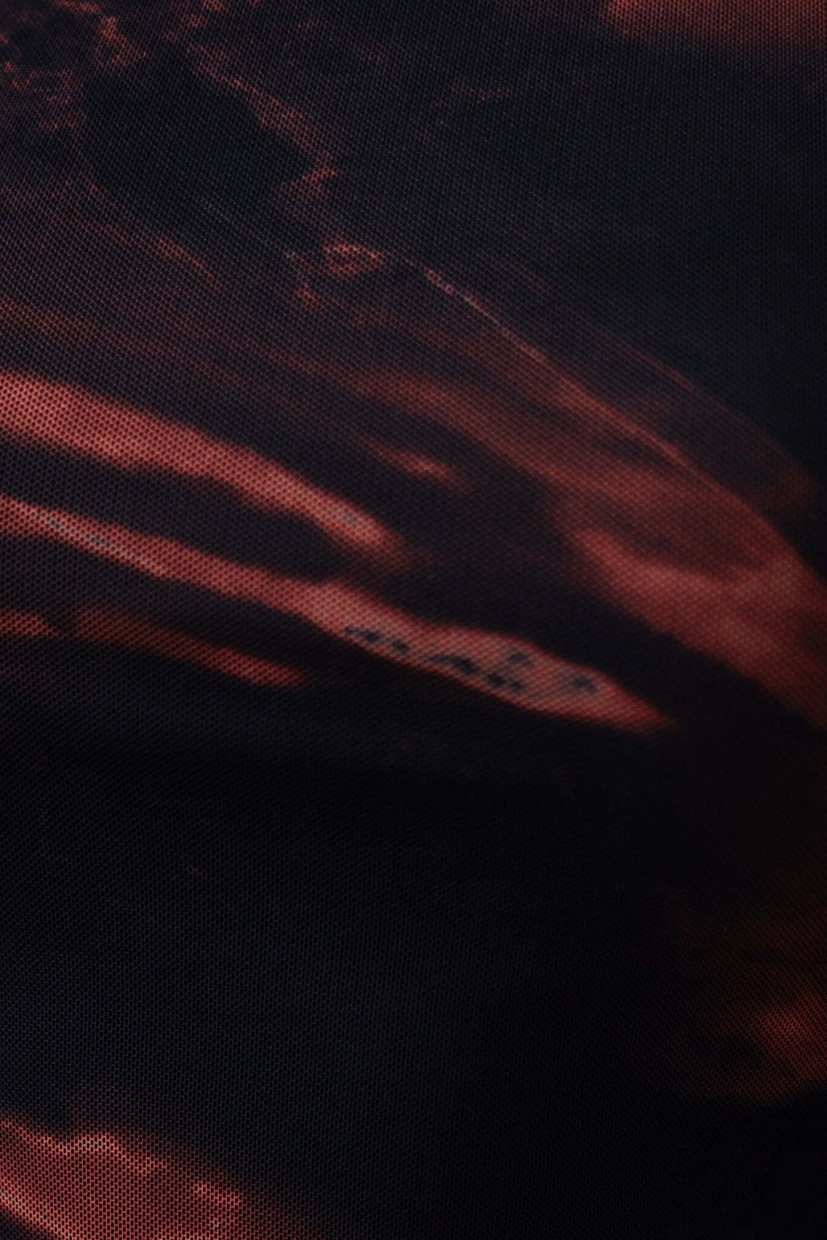 Close-up of textured fabric in black and red hues, showcasing the design details of the Bolzano Maxi Dress.