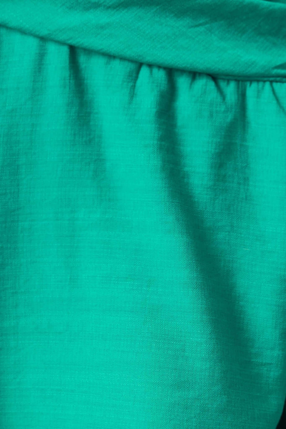 Close-up of vibrant teal fabric showcasing soft texture and subtle pleats, perfect for the Deep Thoughts Dress.