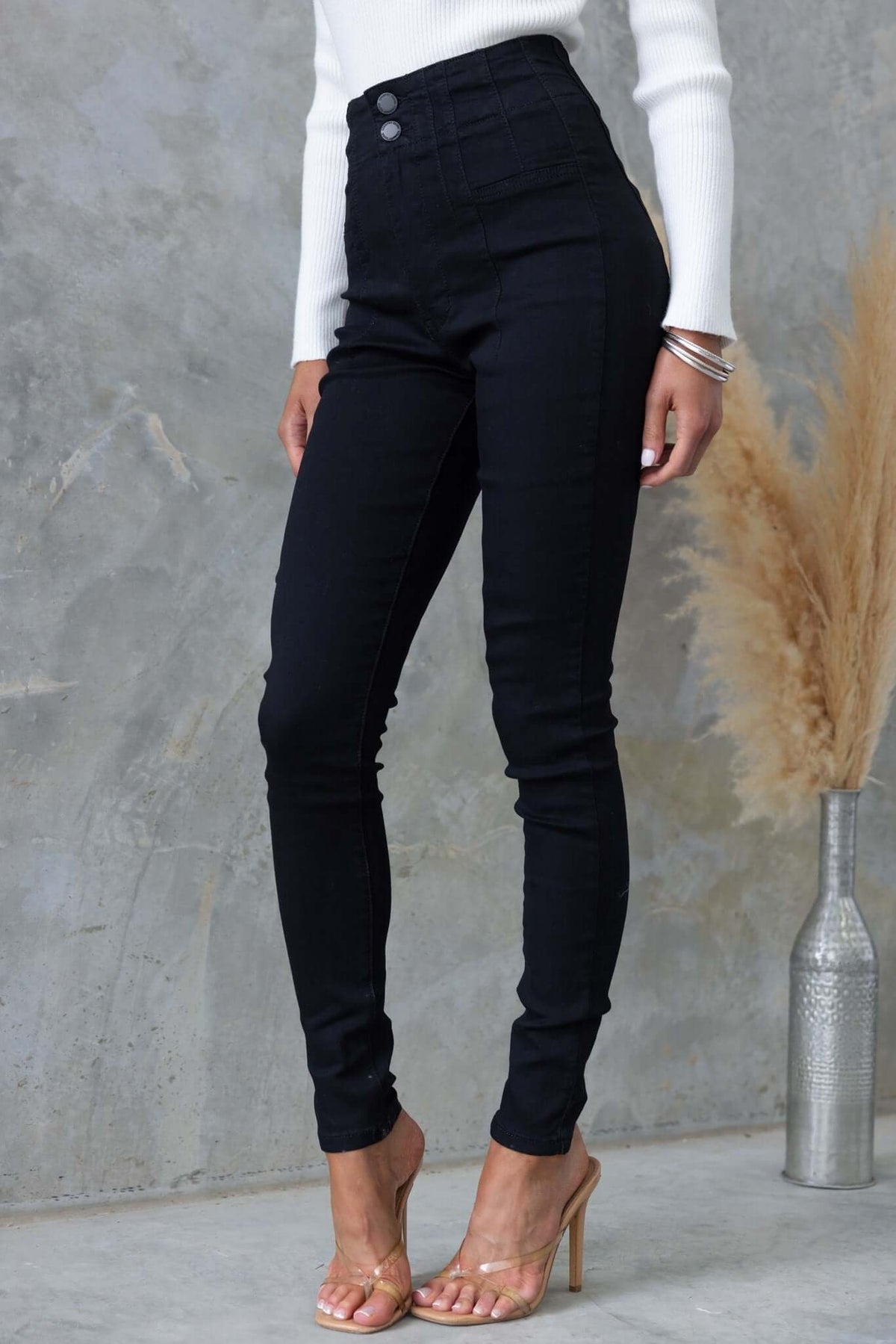 Stylish black denim jeans with mid-high waist, two-button closure, and a firm stretch fit.