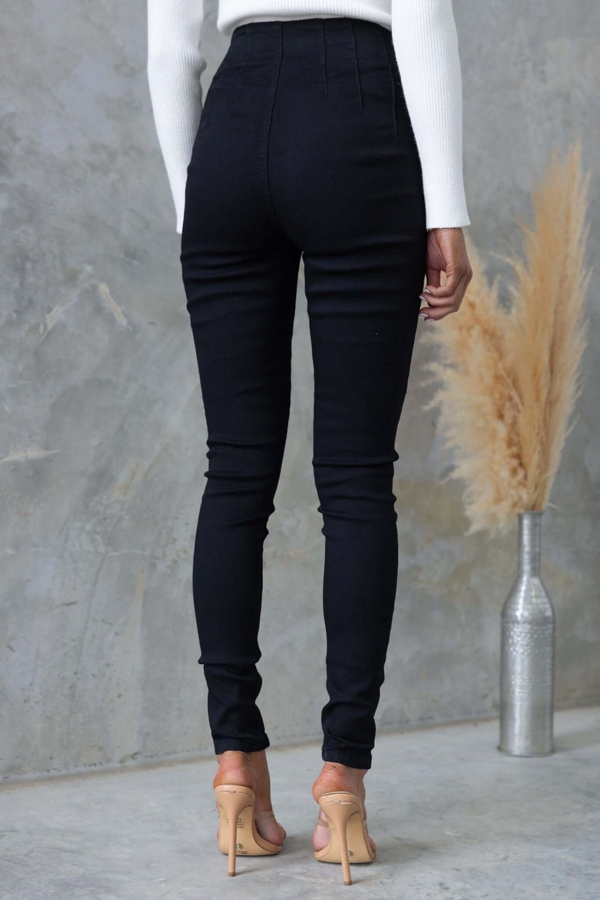 Back view of black denim Okara jeans showcasing mid-high waist and skinny fit.