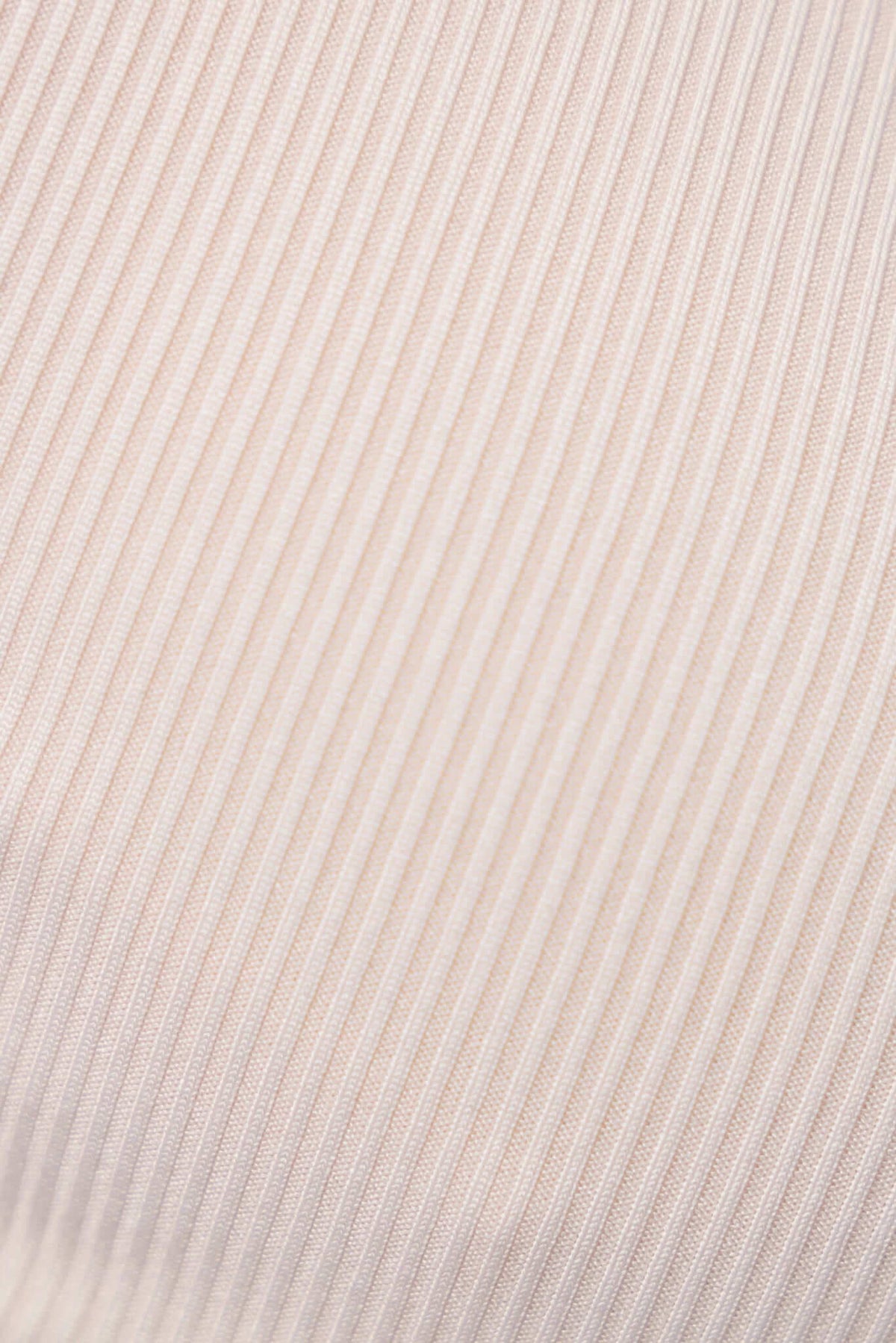 Close-up of ribbed material in light beige, showcasing soft texture and stretch suitable for bodysuits.