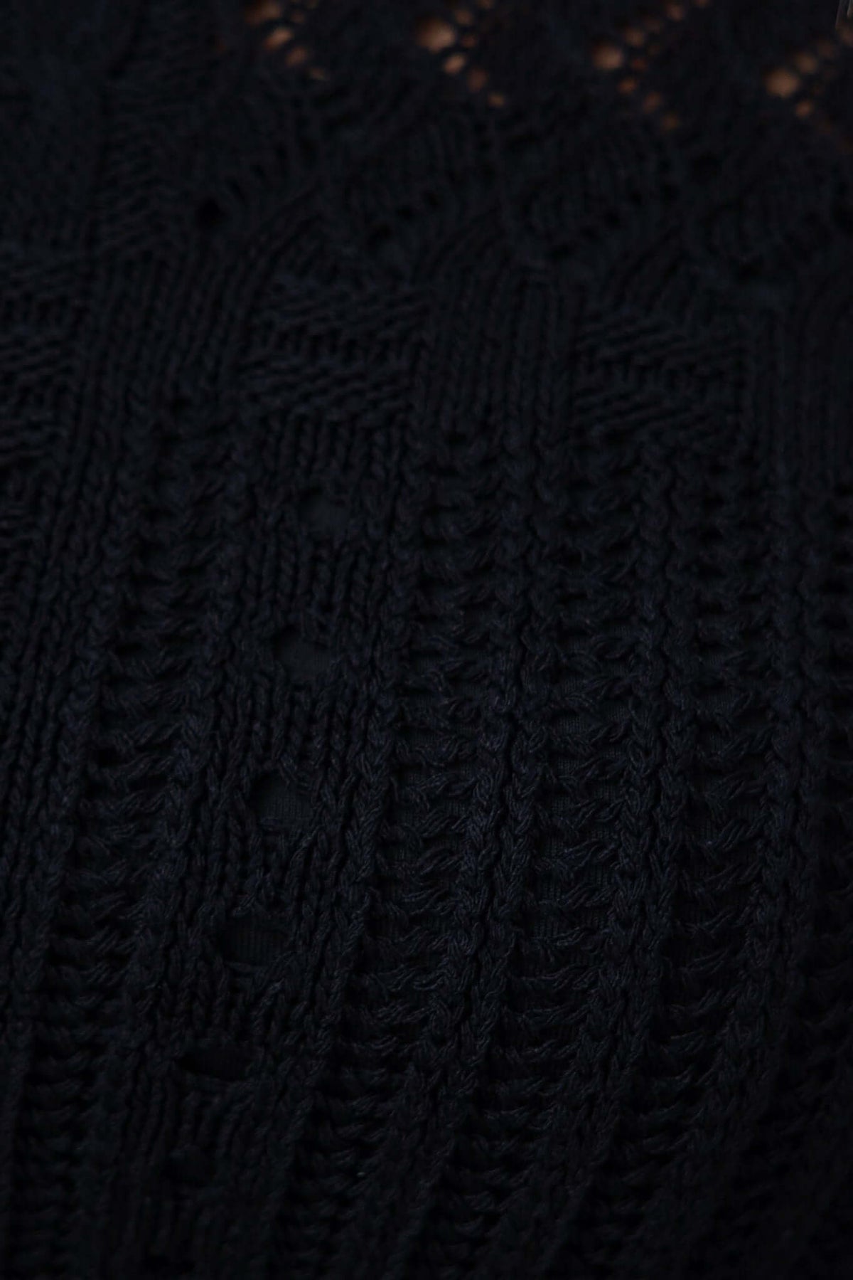 Close-up of black Perilla Top knit fabric featuring intricate detailing and texture.