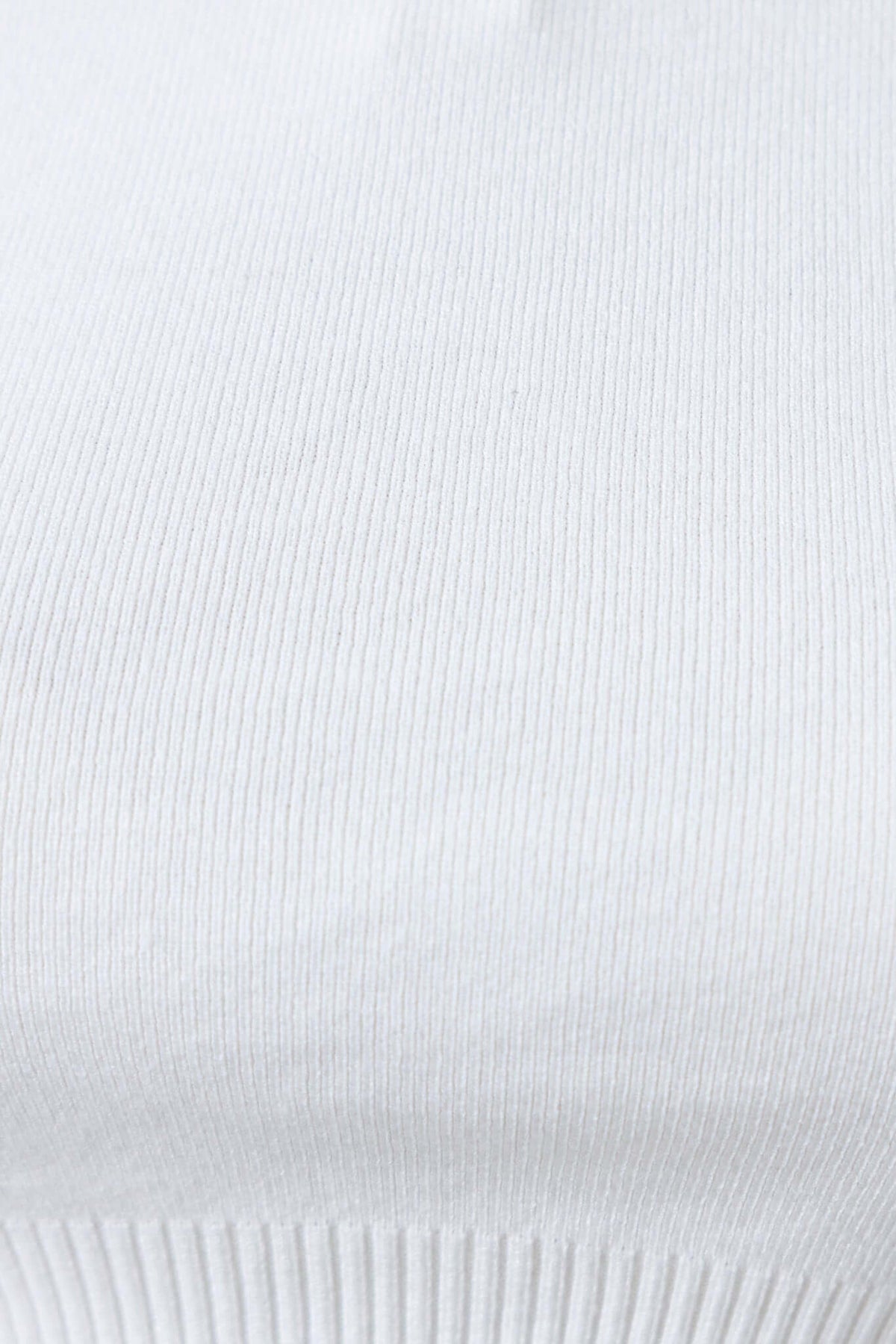Close-up of white knit fabric texture of the Sora Jumper featuring ribbed design and soft material.