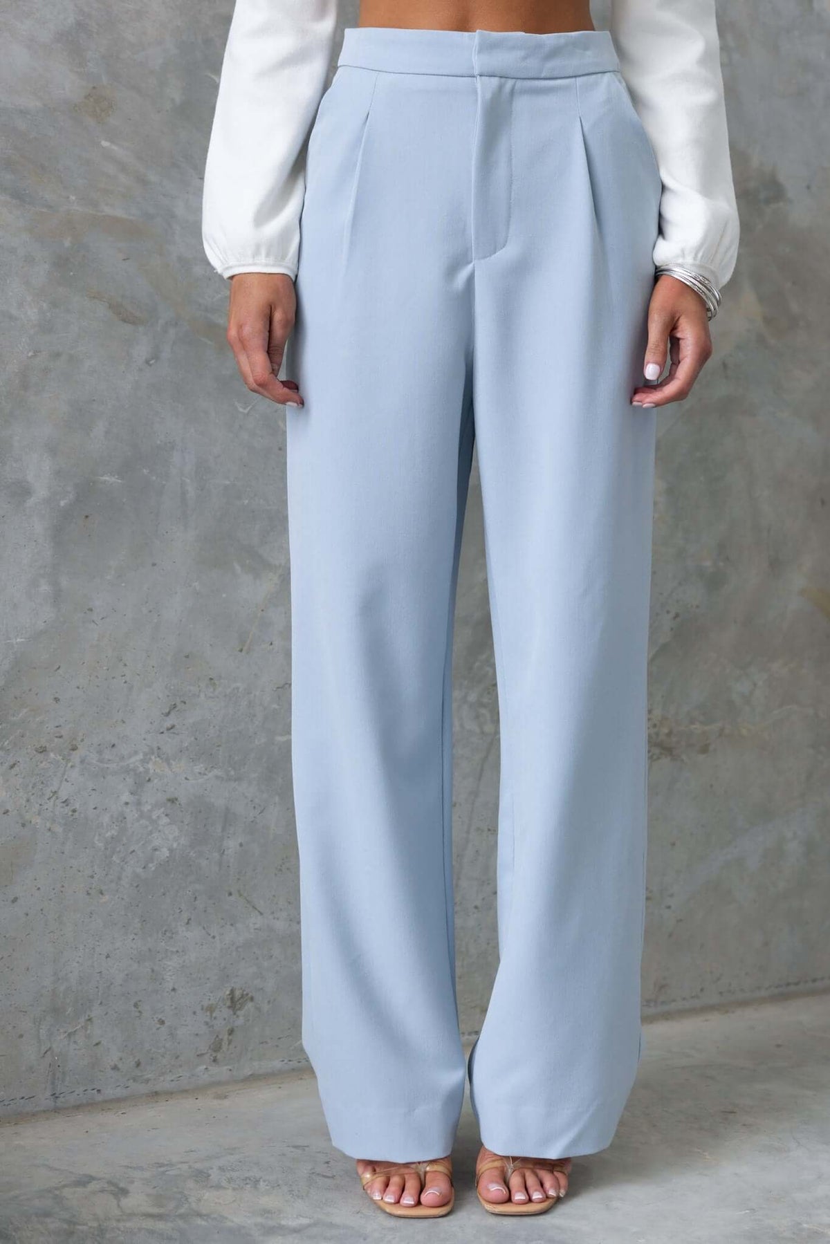 Light blue Kodi pants with wide legs and mid-high waist, worn by a model. Perfect for a stylish, casual look.