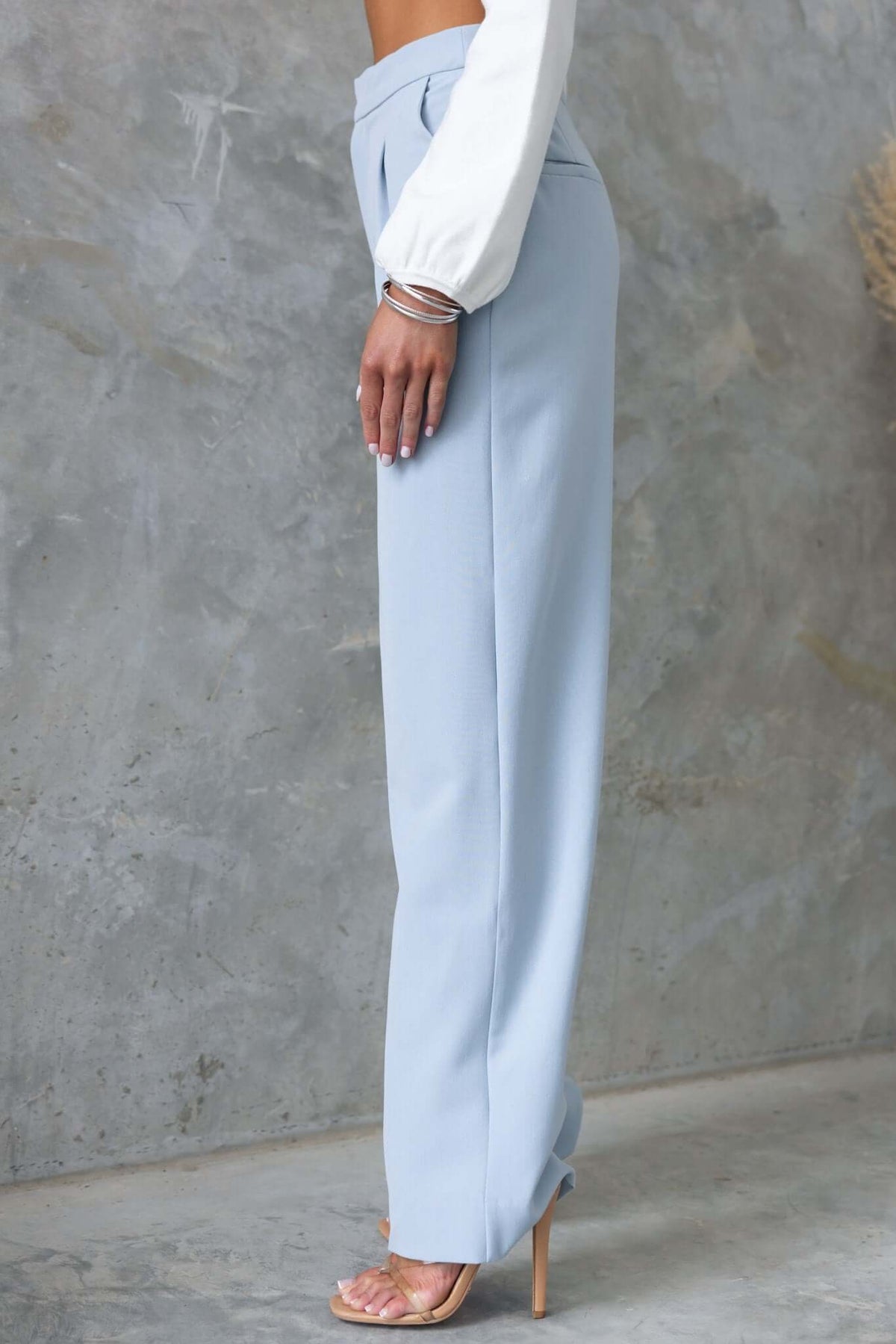 Side view of Kodi Pants in light blue, featuring wide legs and mid-high waist, styled elegantly.