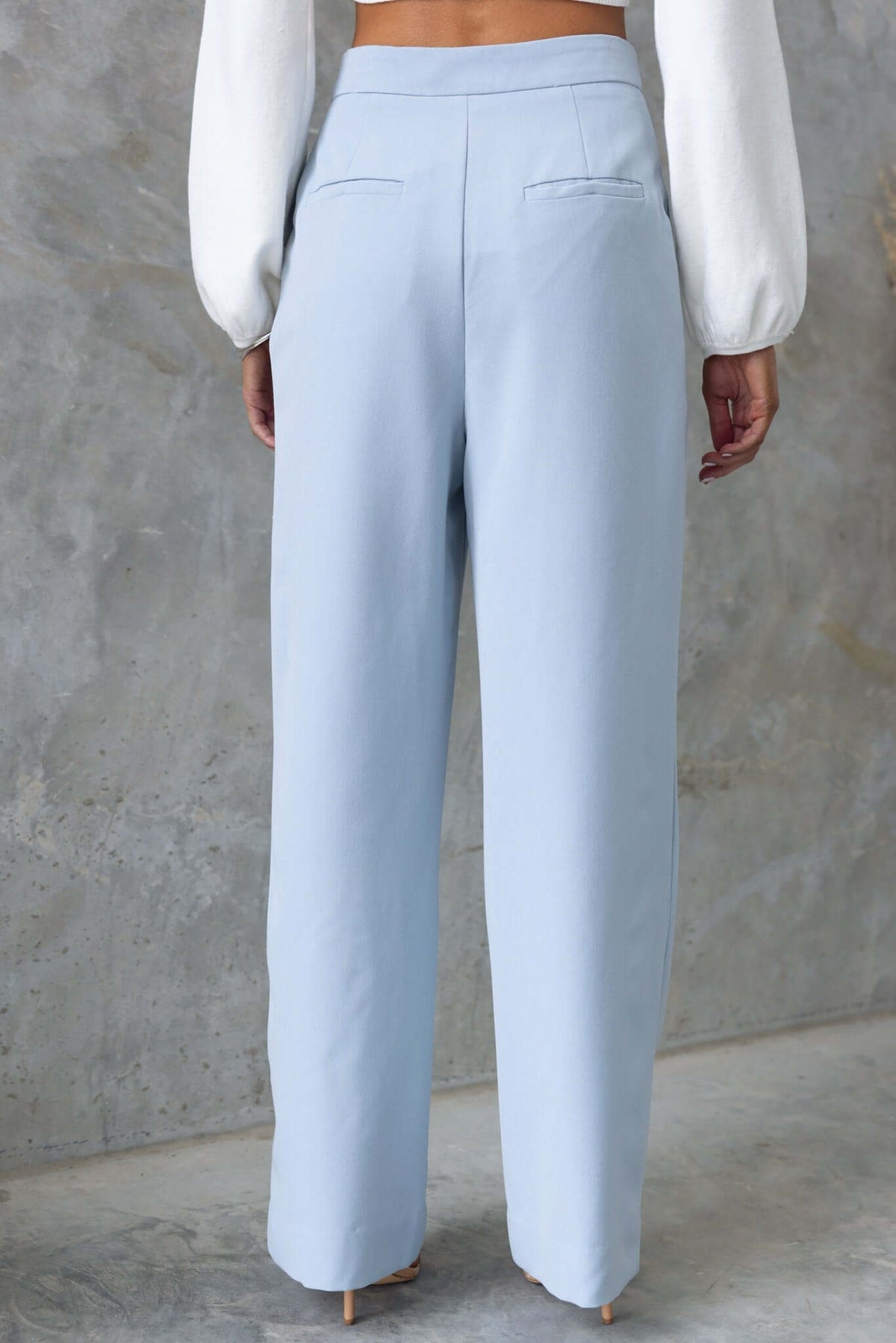 Back view of Kodi pants in light blue with wide legs and mid-high waist, featuring front and back pockets.