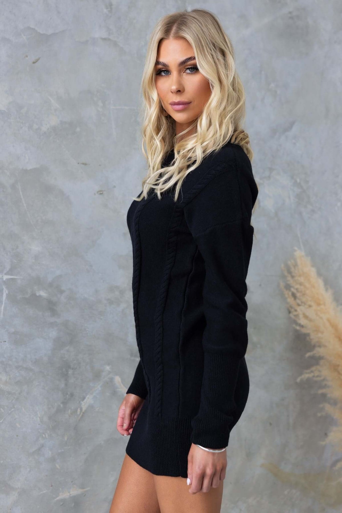 Model wearing a black Beasley Dress with cable knit details, round neckline, and relaxed fit.