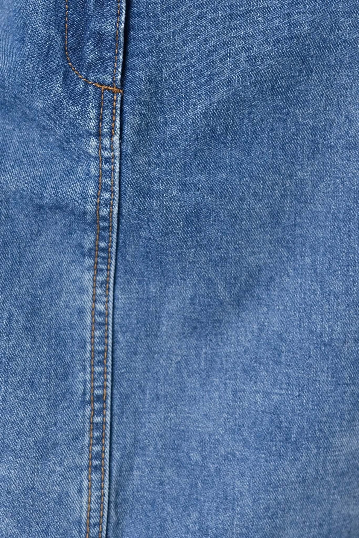 Close-up of barley denim fabric showcasing blue color and stitching details for a stylish denim dress.