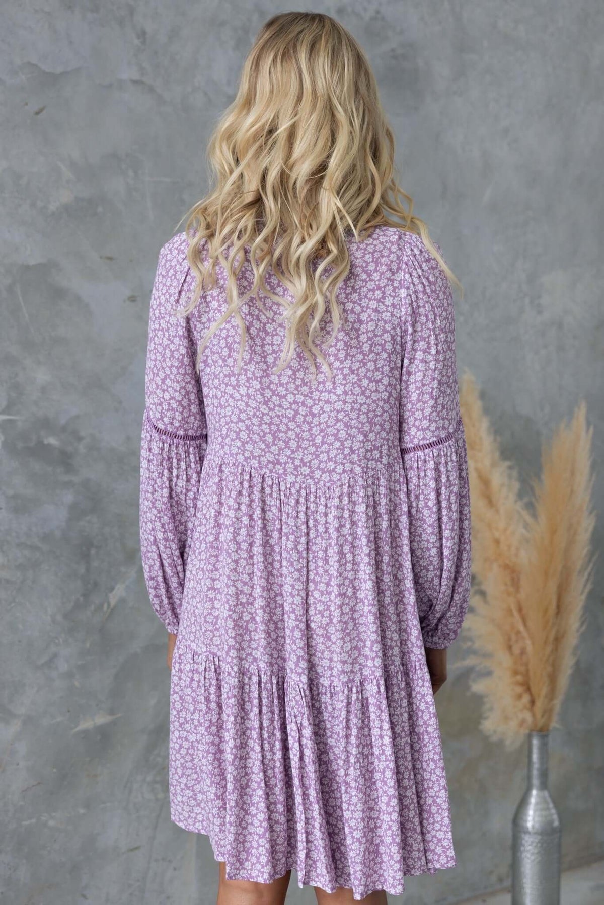 Back view of the Fossa Dress featuring a floral print design, relaxed fit, and long sleeves.