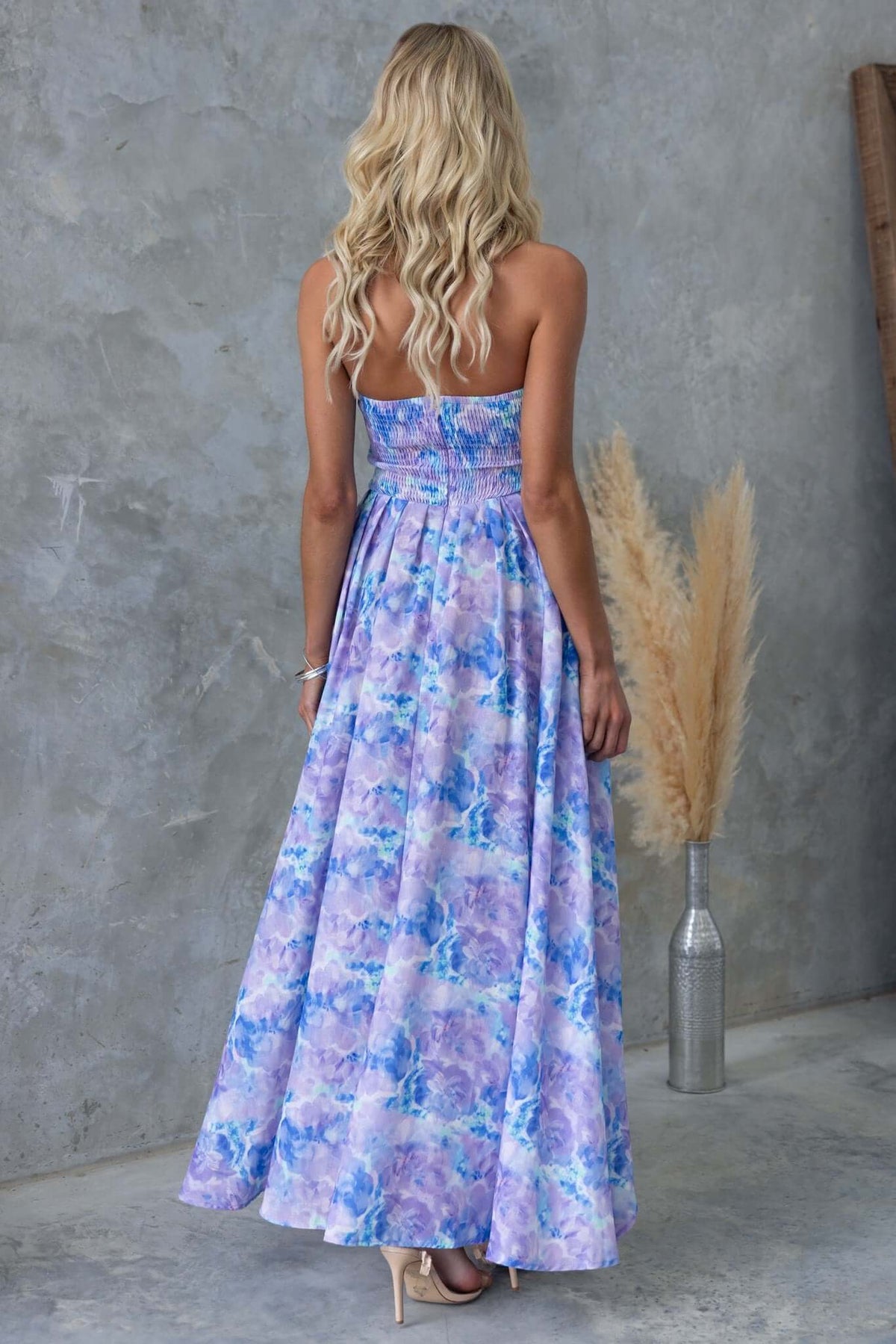 Back view of a strapless Kiss And Tell Maxi Dress in pastel floral design, perfect for summer occasions.