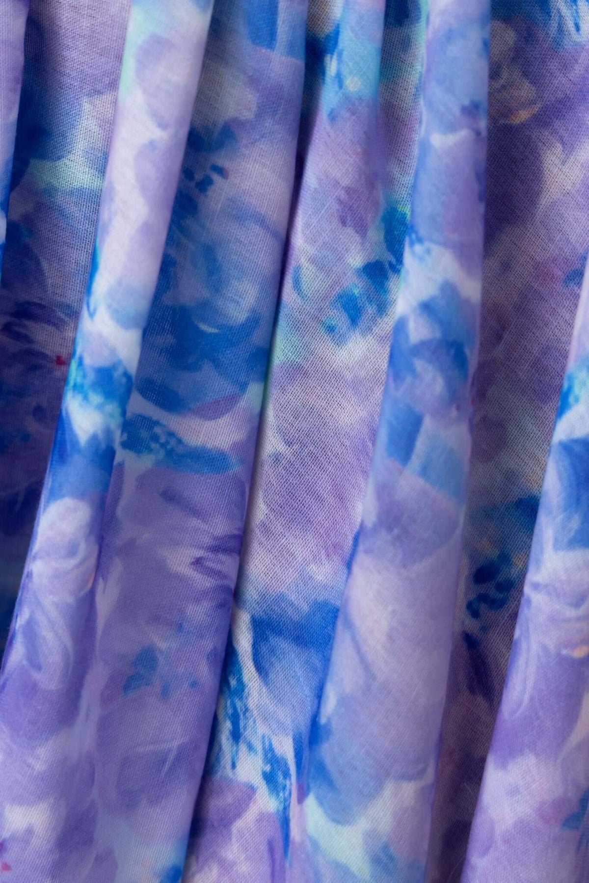 Close-up of the floral patterned fabric used in the Kiss And Tell Maxi Dress, featuring shades of blue and purple.