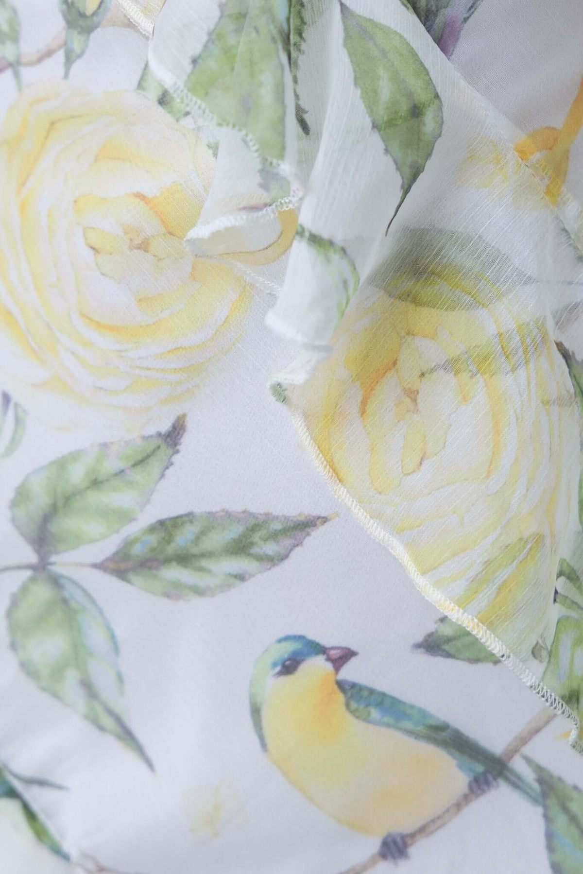 Chiffon fabric detail of Praino Maxi Dress featuring yellow floral pattern and a small bird design.