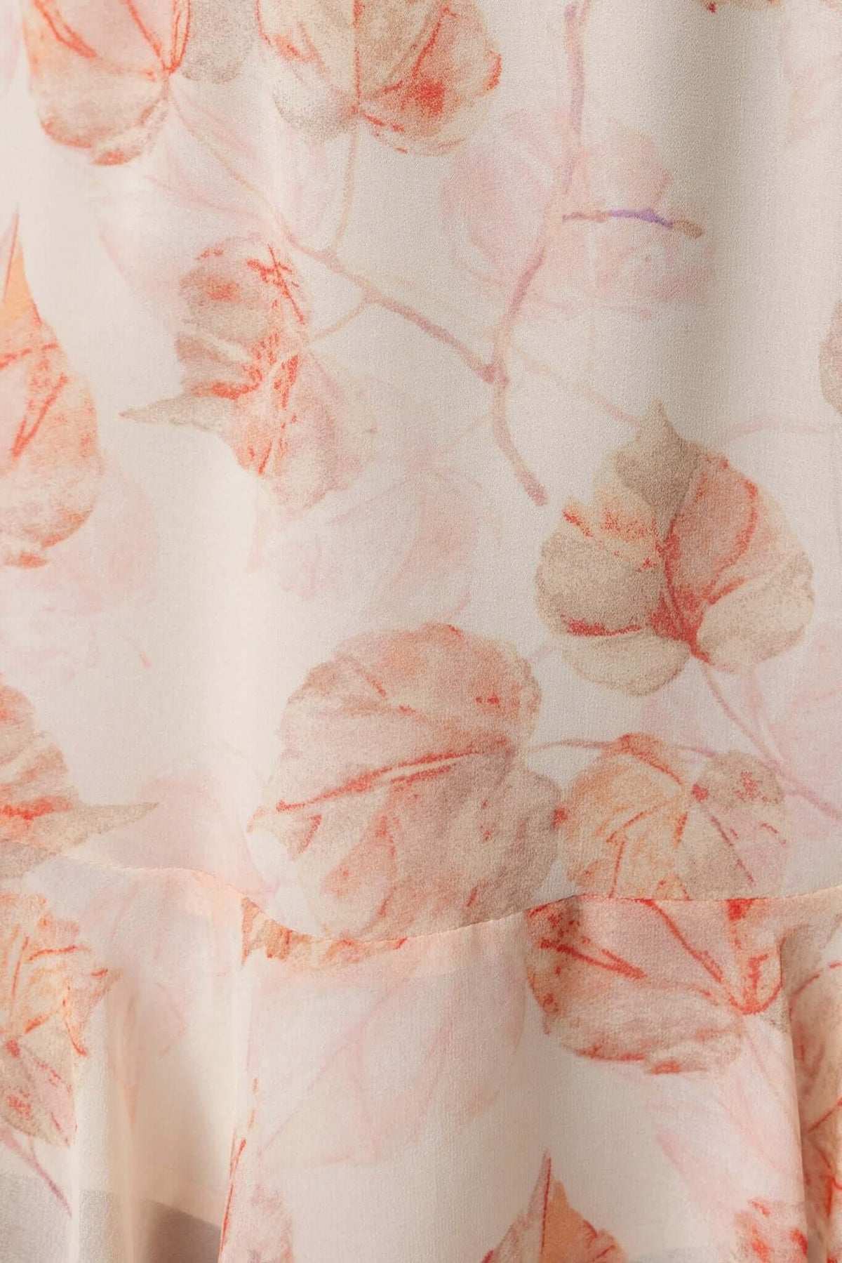 Close-up of Star Drop Dress fabric featuring a delicate floral pattern in soft peach and cream tones.