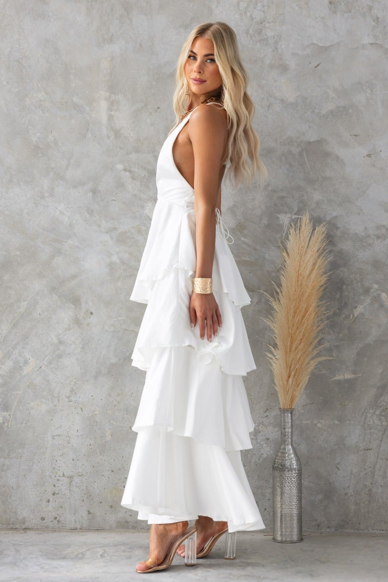 End Of Time Maxi Dress in white with a ruffle skirt, V-neckline, and lace-up back detail.
