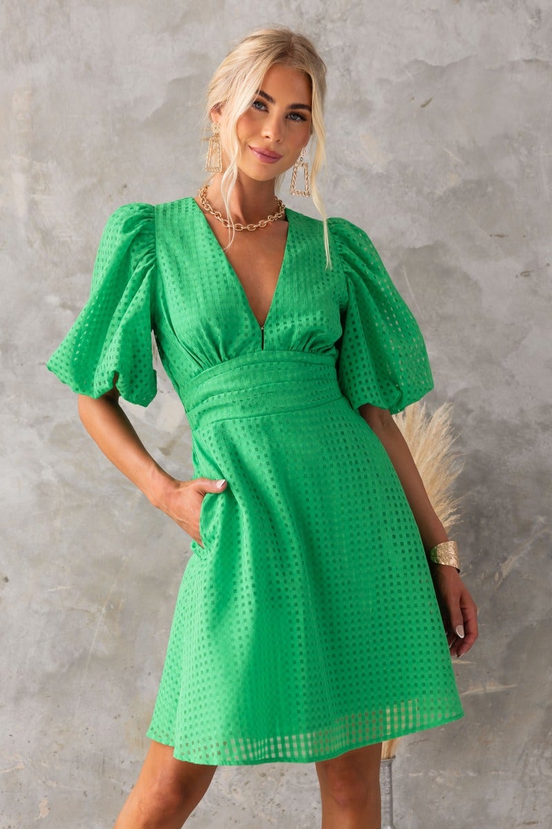 Lantier Dress in vibrant green, featuring a V-neckline, puff sleeves, and pockets, made of lined chiffon material.
