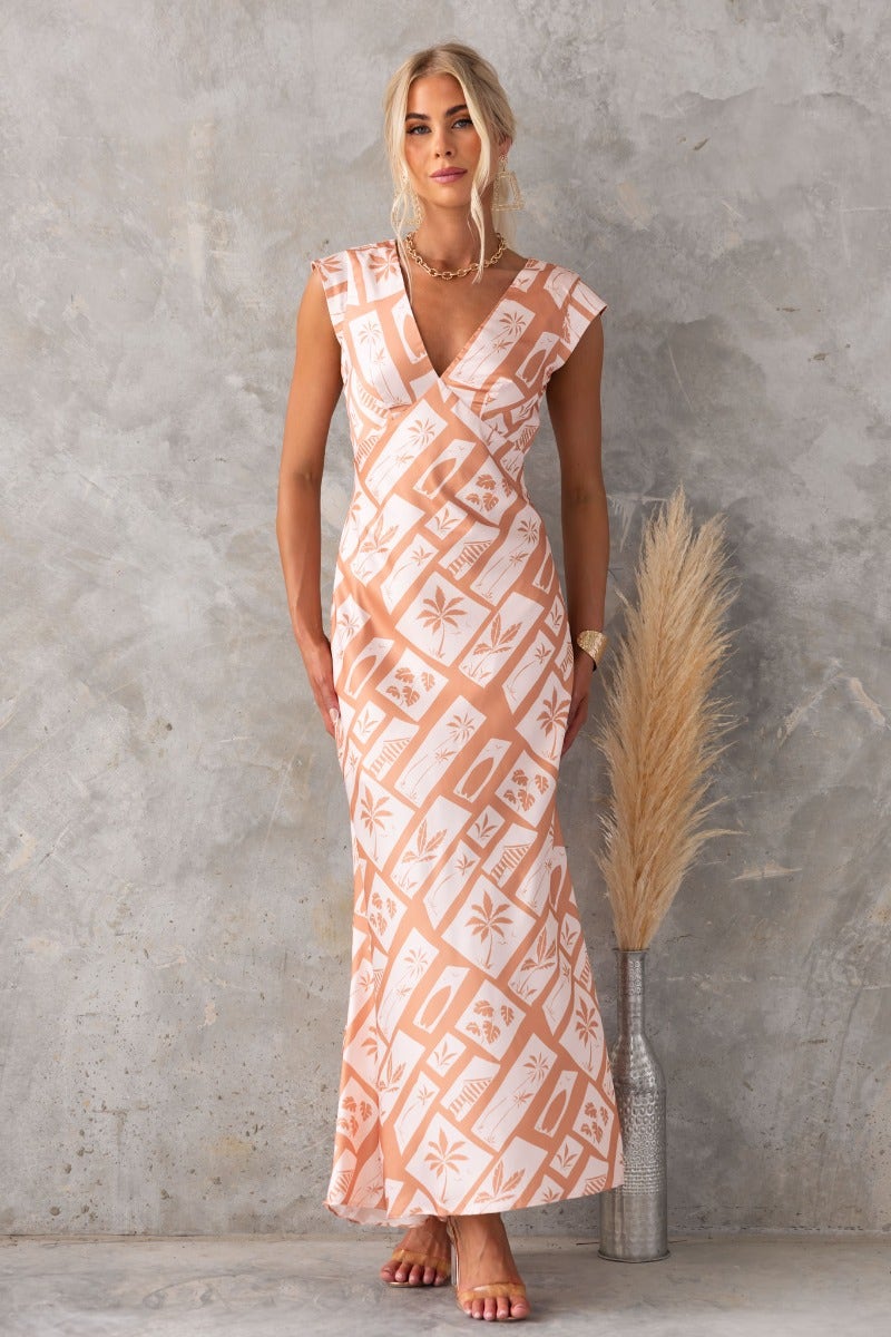 Model wearing a floral print Veneline Maxi Dress with V-neckline against a textured background.