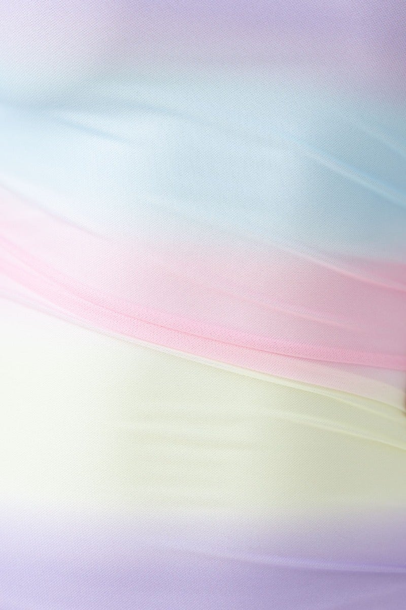Close-up of a pastel gradient mesh fabric showcasing soft colors of blue, pink, yellow, and lavender, ideal for dresses.