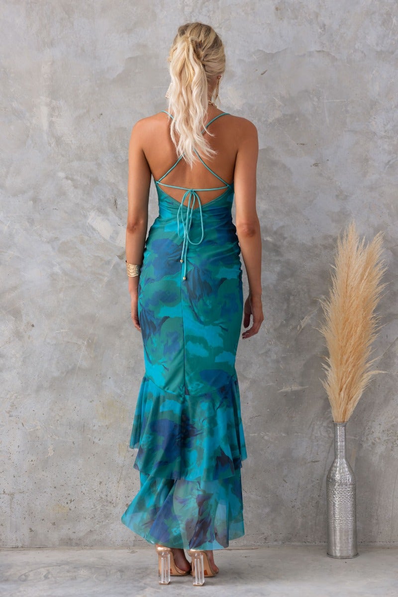 Back view of teal Bad Habits Maxi Dress with adjustable straps and high-low hem, featuring a mesh overlay.
