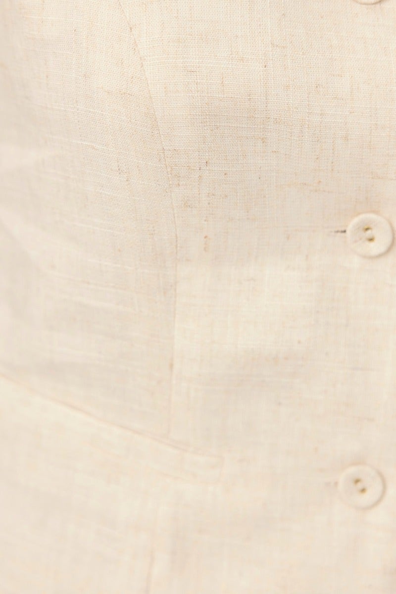 Close-up of Stand Still Top, showcasing button-up front and linen texture in a light cream color.