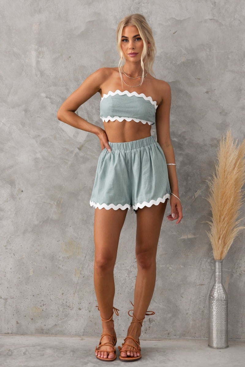 Model wearing Take It Easy Shorts and matching top in light blue with scalloped edges, showcasing a trendy summer look.