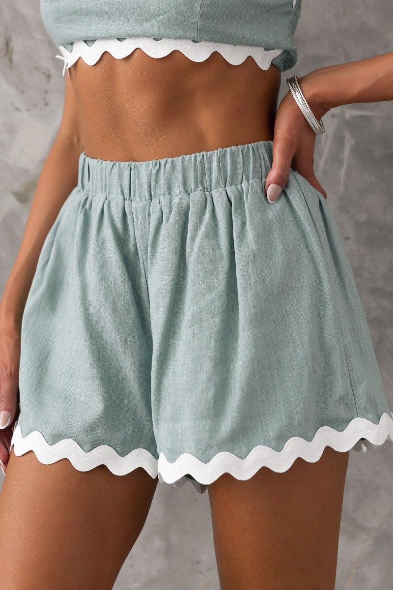Take It Easy Shorts: Mid-high waist, elastic waistband, linen feel, lined shorts in mint green with scalloped hem.