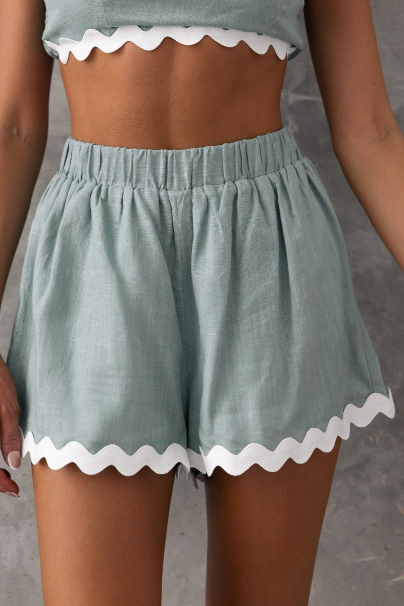Take It Easy Shorts in light blue, mid-high waist, elastic waistband, scalloped hem, perfect for casual summer wear.