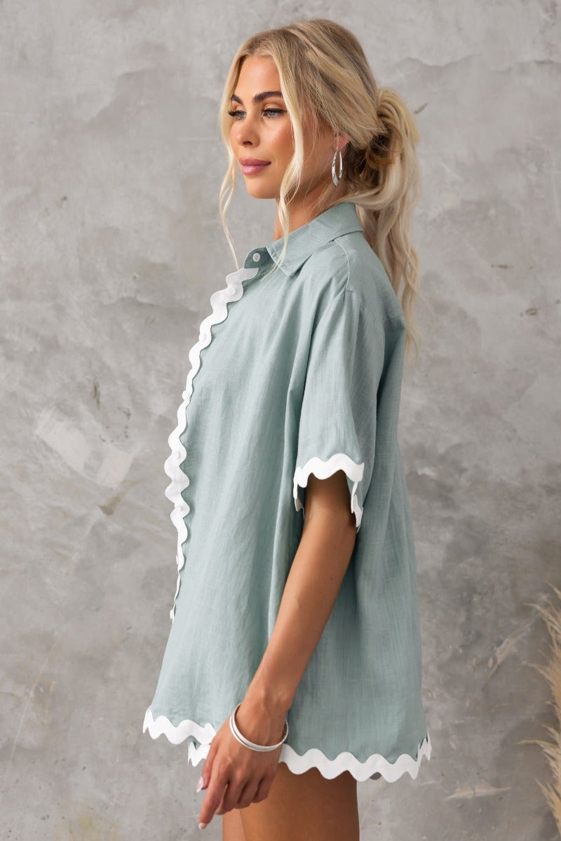 Side view of Take It Easy Shirt in green, featuring scalloped edges and a relaxed fit, made with 70% Rayon, 30% Linen.