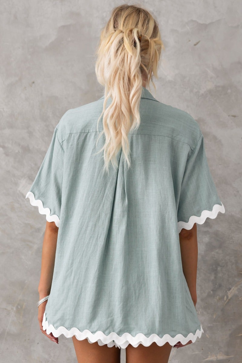 Back view of Take It Easy Shirt in faded green with scalloped hem, styled for relaxed fit and casual wear.